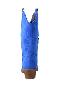 Botas de tobillo de ante azul en estilo western, con punta afilada, costuras decorativas y un tacón marrón de altura media. Incluyen tiradores en los laterales.