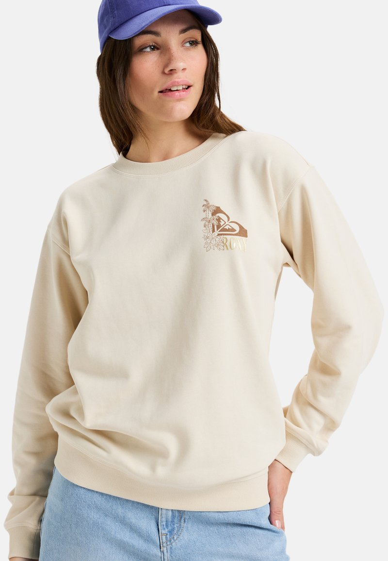 Beige sweatshirt met ronde hals, gemaakt van zachte katoen, met een bruine tropische graphic en "ROXY" tekst op de linkerkant van de borst.