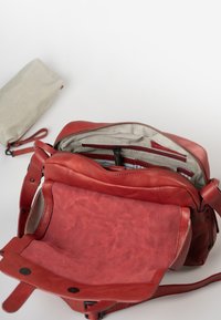 Borsa in pelle rossa con finitura testurizzata, dotata di una parte superiore con zip, fodera in tessuto a righe e numerose tasche interne. Include un piccolo pouch grigio.
