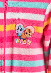 Monos de forro polar con cremallera, en colores rosa, blanco, naranja y azul verdoso con rayas. Presenta un parche bordado de dos perros de dibujos animados en un corazón con la palabra "AMIGOS".