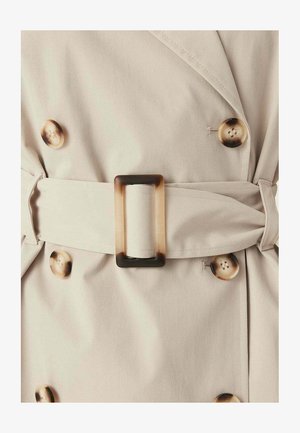 Lichtbeige trenchcoat met grote schildpadknopen en een bijpassende stoffen riem met een rechthoekige schildpaddensluiting.