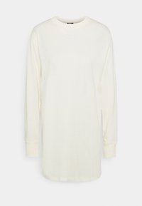 T-shirt a maniche lunghe in cotone color crema chiaro con scollo rotondo e polsini regolabili, caratterizzato da un piccolo logo Nike bianco sul petto.