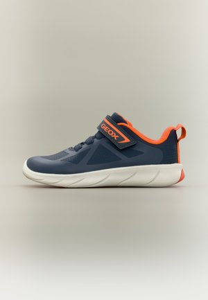 Baskets bleu marine avec des accents orange, semelle blanche, sangle Velcro portant l’inscription "GEOX," et boucle orange au talon sur fond neutre.