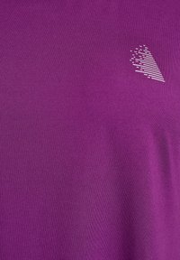 Lilla kortærmet t-shirt lavet af blødt, glat stof med et subtilt hvidt grafisk design på den øverste venstre front.