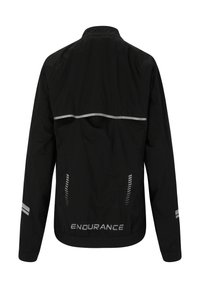 Svart vattentålig jacka med hög krage, reflekterande detaljer och elastiska ärmslut. Har en bakre ventil och logotyp vid fållen.