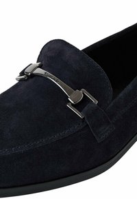 Tume mereva suede loafer hõbedaste detailidega ja sileda kummitaldaga. Ümber ääre on läikiv õmblus, mis lisab tekstuuri.
