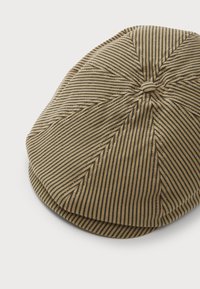 Gorra plana a rayas marrón y negra hecha de tela texturizada, con forma redondeada y detalle de botón en la parte superior.