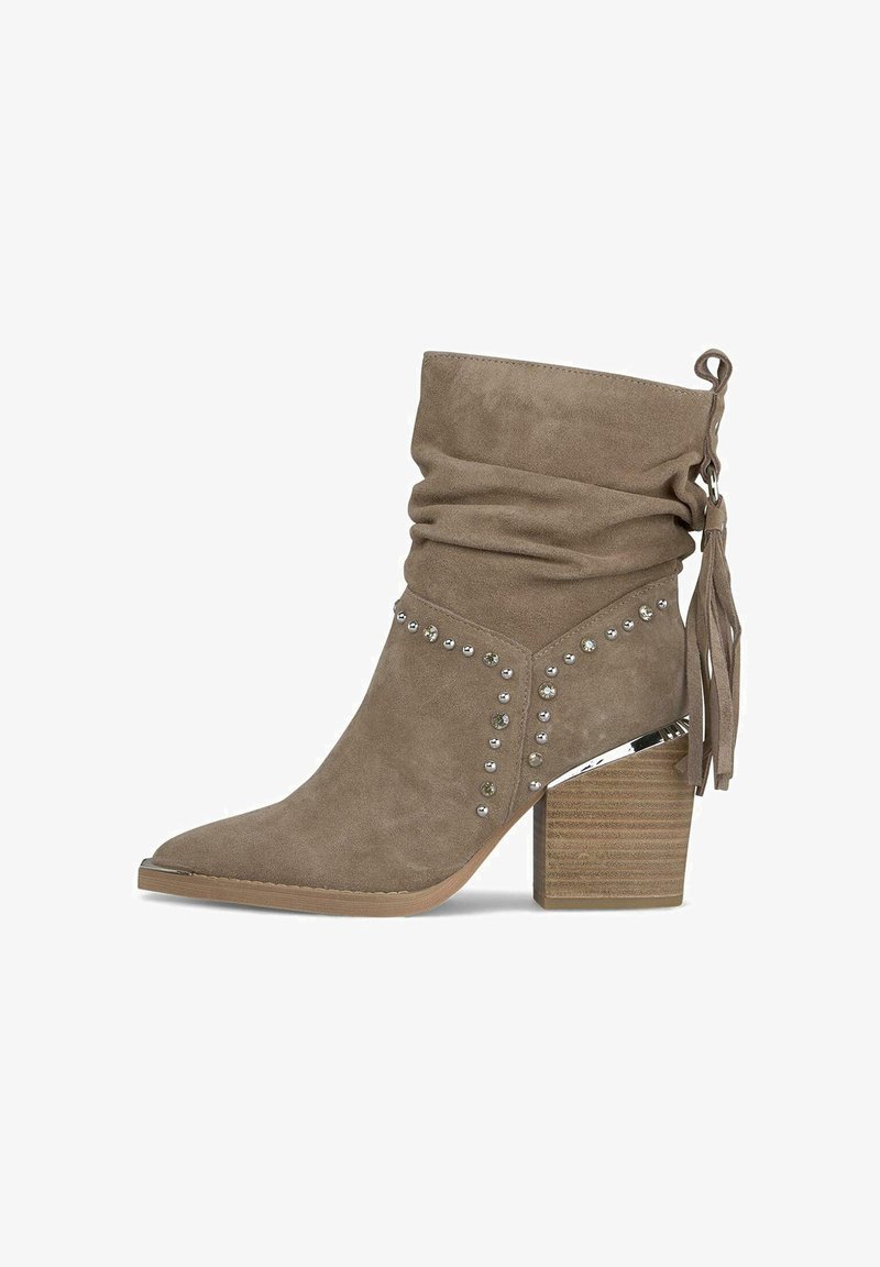 Beżowe zamszowe botki do kostki o luźnym kroju, z metalowymi ćwiekami, ozdobnymi frędzlami i masywnym drewnianym obcasem. Szpiczasty nosek.