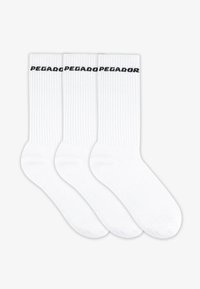 Fehér pamut zoknik, három pár, bordázott textúrával és a tetején fekete nyomtatott "PEZADOR" logóval. Szokásos crew hossz.
