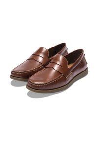 Une paire de mocassins en cuir marron, à enfiler, avec des coutures moc toe et des semelles en caoutchouc, présentée sur fond blanc.