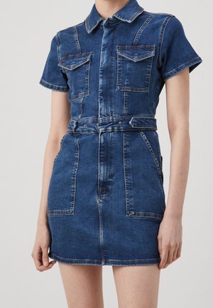 Spijkerjurk met korte mouwen, kraag, twee voorzakken, ceintuur in de taille en een verweerde blauwe textuur. Heeft een aansluitend silhouet en een knoopsluiting.