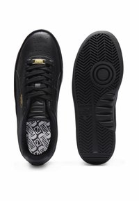 Czarne sneakersy z gładką skórzaną cholewką, teksturowaną powierzchnią, złotymi akcentami i wzorzystą wkładką. Gumowa podeszwa ma bieżnik w kształcie jodełki.