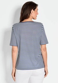 Gestreiftes T-Shirt in Marineblau und Weiß mit kurzen Ärmeln, rundem Ausschnitt, weichem Stoff und seitlichen Schlitzen, von hinten betrachtet.