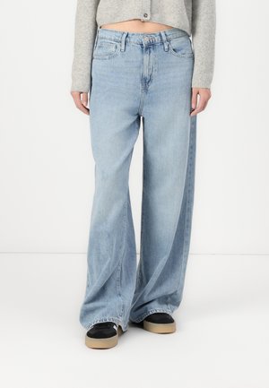 Jean bleu clair, ample, à taille haute et jambes larges. Design classique à cinq poches, ourlet effiloché et texture denim durable.