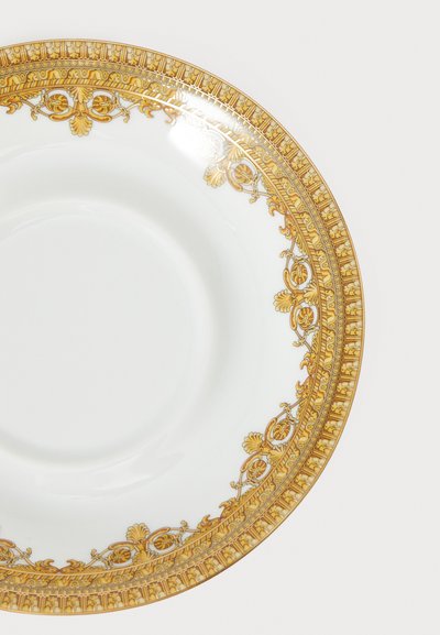 Posliinilautanen, jossa valkoinen keskusosa ja koristeellinen kullanvärinen reunus, jossa on monimutkaisia kukka- ja geometrisia kuvioita.