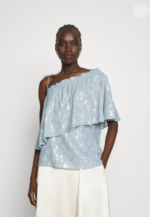 Ανοιχτό μπλε τοπ με σχέδιο ενός ώμου, στρωτές ρυτίδες και ασημένια υφή. Διαθέτει έναν ενιαίο ιμάντα και άνετη εφαρμογή.