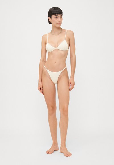 Crème-kleurige bikini-set bestaande uit een triangle bralette met dunne bandjes en een bijpassende string-broek. De stof heeft een zachte, gestructureerde afwerking.