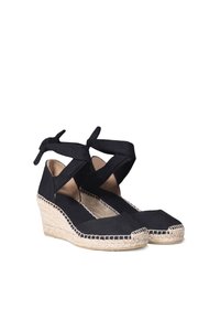 Le espadrillas con wedge in tela nera presentano una suola in juta intrecciata, una punta quadrata piatta e cinturini alla caviglia incrociati. I dettagli cuciti accentuano i bordi.