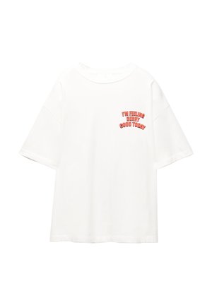 T-shirt in cotone bianco con maniche corte, caratterizzata da un testo rosso che recita: "MI SENTO MOLTO BENE OGGI" sulla parte sinistra del petto.