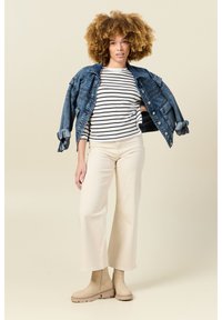 Jeansjacke mit hochgekrempelten Ärmeln, gestreiftes Langarmhemd, cremefarbene Weitbein-Hosen und beigefarbene Stiefeletten. Einfaches, lässiges Outfit-Design.