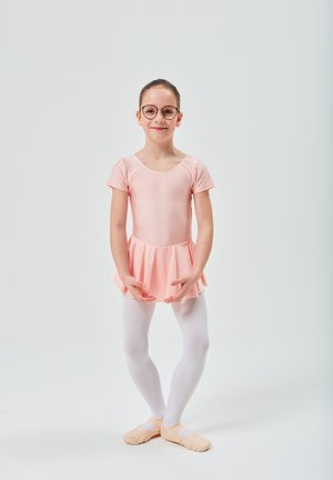 Pink ballet leotard with ruffled skirt, white tights, and light ballet shoes. Child wears round glasses and stands with arms positioned gracefully.