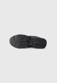 Schwarze Sportschuhsohle aus strukturiertem Gummi für Grip. Verfügt über ein geformtes Muster und Erhöhungen für Traktion. Schlankes, ergonomisches Design.