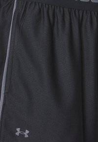 Sorte treningsshorts laget av teksturert stoff, med en grå aksentstripe og et grått Under Armour-logo. Elastisk livlinje.