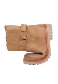 Beżowy zamszowy botek za kostkę z wełnianą wyściółką, bocznym paskiem z klamrą oraz solidną gumową podeszwą z głębokim bieżnikiem zapewniającym przyczepność.