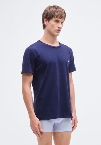 T-shirt de algodão azul-marinho de mangas curtas com decote redondo e pequeno logótipo no peito. Textura lisa, corte ajustado.