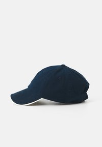 Marineblå bomulds-baseballkasket med en buet skygge, seks-panel design og hvid accent-syning langs skyggen.