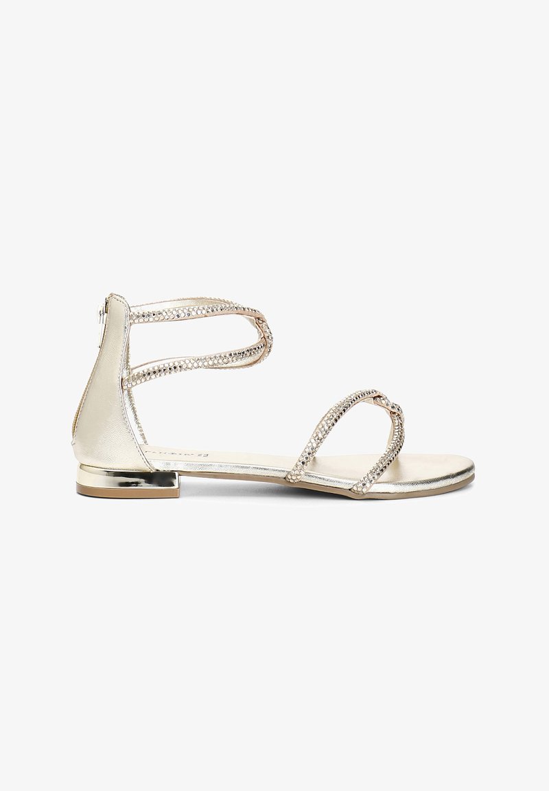 Złote metaliczne płaskie sandały mają dwa plecione paski ozdobione kryształkami oraz mały, szlifowany obcas. Gładka faktura z metalicznym wykończeniem.