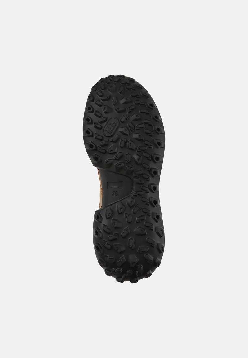 Suola di una scarpa con una robusta gomma nera, caratterizzata da lugs di trazione multidirezionali e una superficie texturizzata per una buona presa.