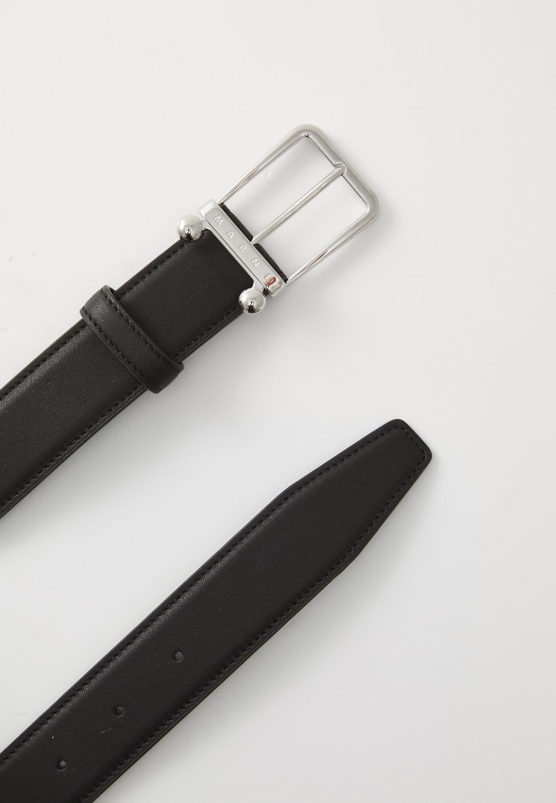 Cintura in pelle nera con una fibbia rettangolare argentata caratterizzata da due dettagli a pallina. Texture liscia, bordi dritti e diversi fori per la regolazione della misura.
