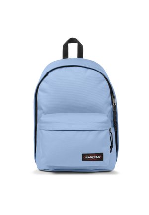 Mochila de color azul claro con un acabado de tela suave, forma redondeada, un bolsillo frontal con cremallera y acentos de cremallera negra. Presenta un asa en la parte superior.