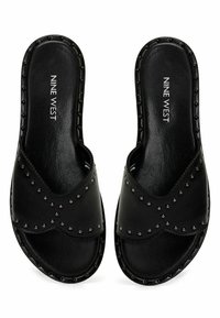 Sandali neri in pelle con slip-on, caratterizzati da dettagli in metallo e una texture liscia. Design open toe con una forma sagomata per il comfort.