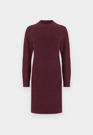Vestido de malha até ao joelho, de manga longa, em bordeaux profundo, com gola alta, punhos e barra canelados, em fundo branco.