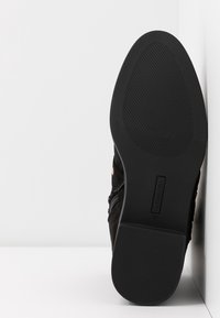 Czarne zamszowe buty z teksturowaną cholewką i gumową podeszwą. Charakteryzuje się gładkim designem, zaokrąglonym noskiem oraz zamkiem błyskawicznym z boku. Rozmiar 37.