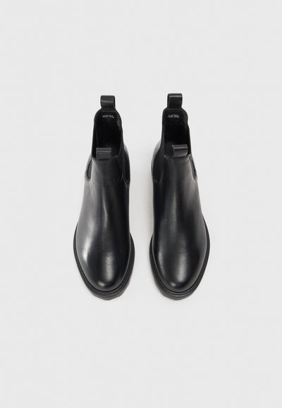 Zwarte leren enkelbooties met een gladde textuur, elastische zijkanten en trekflappen. Rond de neus en platte zool. Minimalistisch ontwerp.