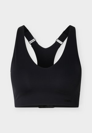 Brassière de sport noire avec bretelles ajustables en style dos nageur et design sans coutures, marquée du texte "Stronger" sur le bas à droite.
