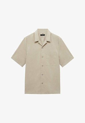 Bež majica kratkih rukava od glatke tkanine, s izrezanim ovratnikom, kopčanjem na dugmad, jednim džepom na prsima i opuštenim krojem.