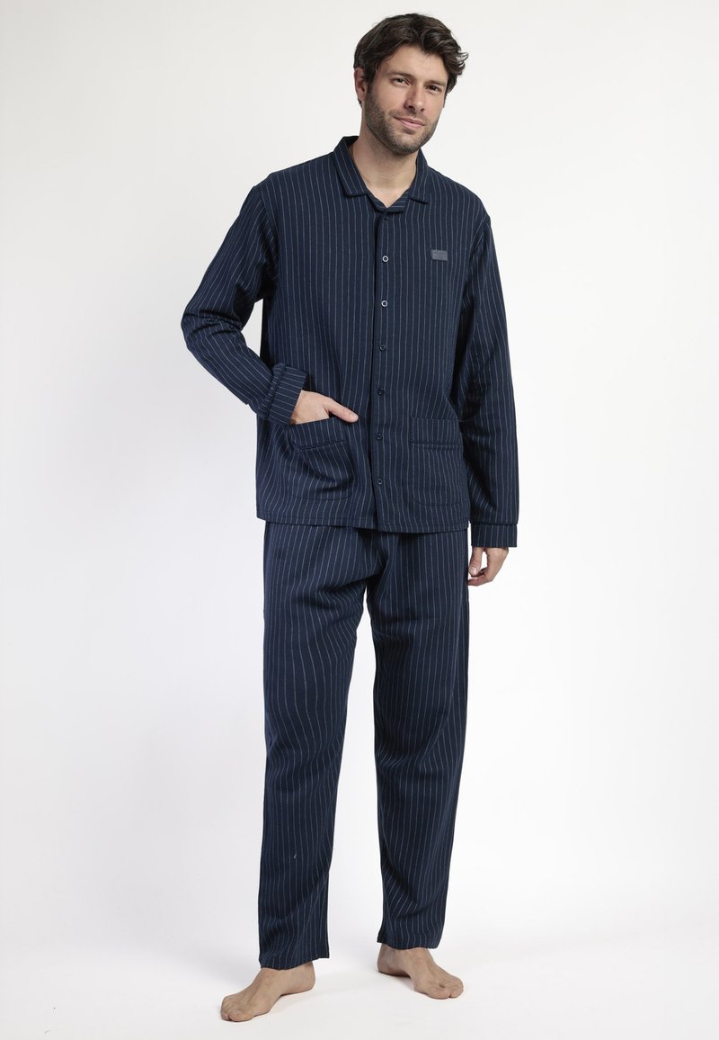 Pijamas a rayas azul marino hechos de tela suave; parte superior con botones y un bolsillo, pantalones a juego con cintura elástica, corte relajado.