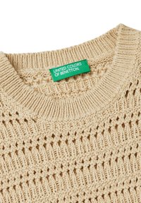 Maglione a maglia beige con un motivo testurizzato, colletto a girocollo a coste e un'etichetta verde con il marchio "United Colors of Benetton."