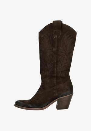 Botte de cowboy en suède marron avec une couture décorative sur le haut, un bout pointu et un talon empilé. Équipée d'une languette pour faciliter l'enfilage.
