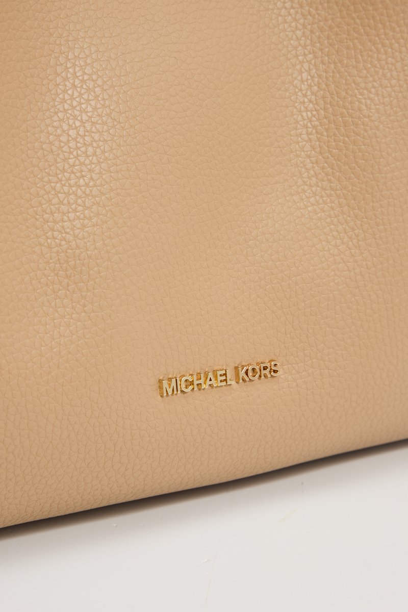 Bolso de mano de cuero beige con superficie texturizada, logotipo en metal dorado estampado y un diseño simple sin adornos adicionales.