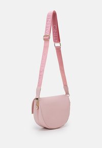 Rosa läder crossbody-väska med en böjd form, som har en djärv rosa rem präglad med "VALENTINO" och guldaccents.