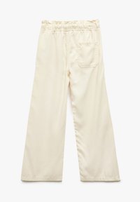 Pantaloni color crema con vestibilità rilassata, cinturino elasticizzato e una tasca posteriore. Tessuto morbido e gamba ampia.