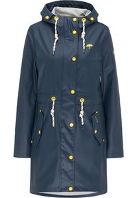 Imperméable bleu marine avec capuche, boutons jaunes, cordons blancs avec perles en bois, deux poches avant à rabat et petit logo parapluie jaune sur la poitrine.