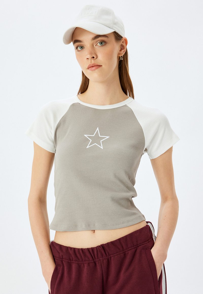 Grå ribbet t-shirt med korte ærmer og hvide raglan ærmer samt et centralt hvidt stjernes grafik, parret med bordeaux bukser med elastisk talje.