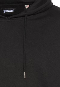 Czarna bluza z kapturem wykonana z miękkiej, fakturowanej tkaniny. Posiada sznurek ze stalowymi końcówkami oraz metkę z logo na wewnętrznym kołnierzu.