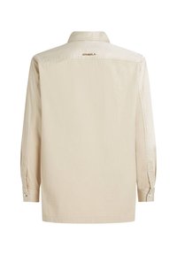 Camisa de manga larga beige de tejido suave con una textura ligeramente brillante, que presenta un cuello clásico y puños abotonados, con un sutil logo.